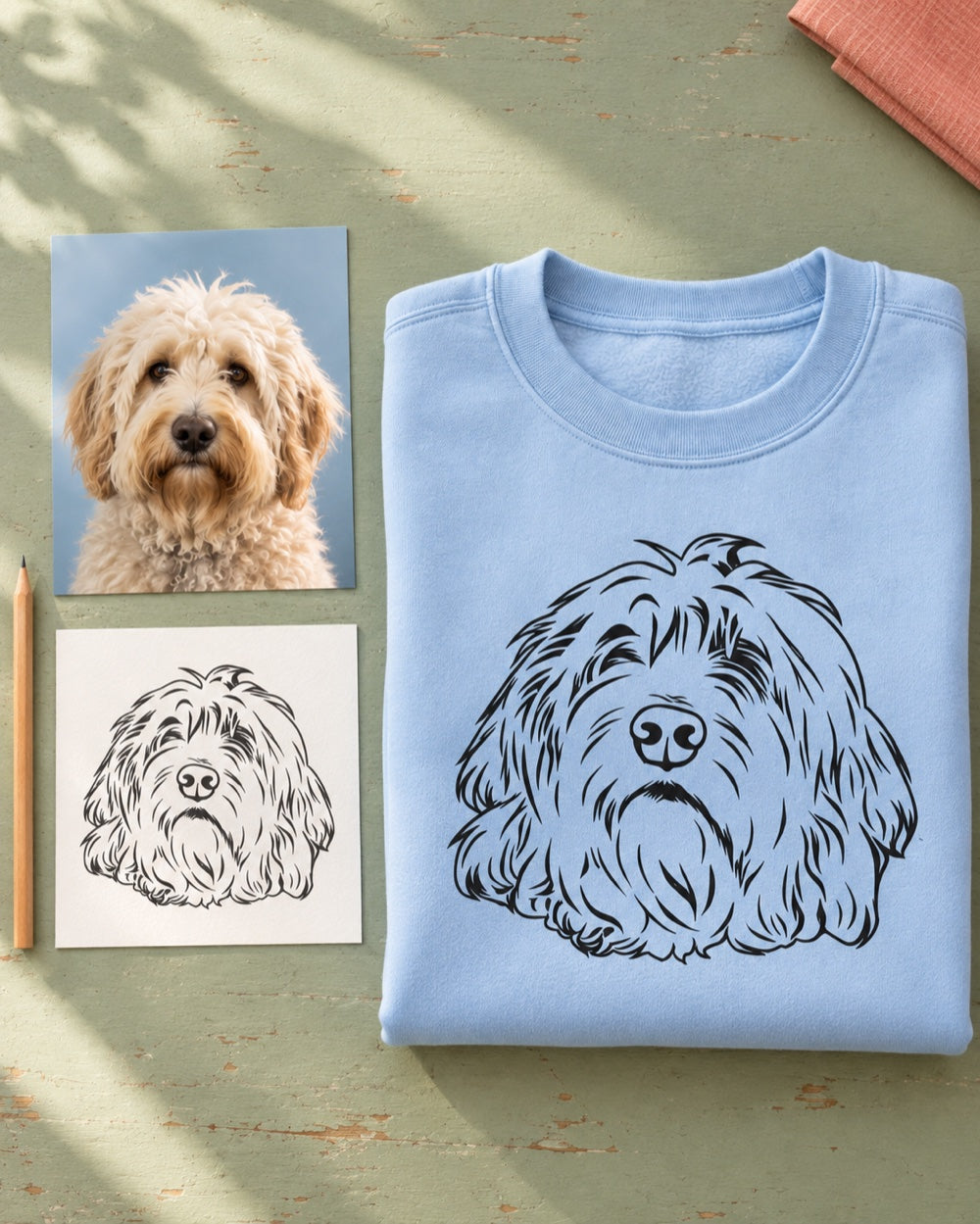 A shaggy dog's photograph, matching line-art portrait and light-blue sweatshirt arranged together