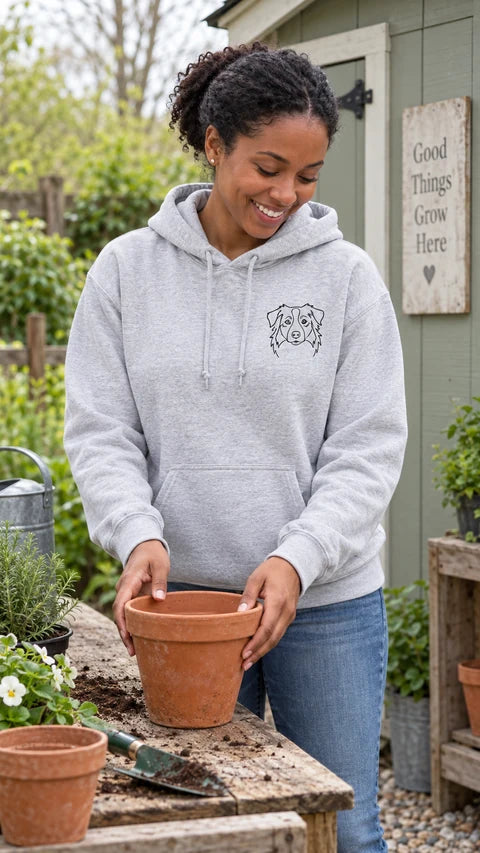 Sport grey custom dog hoodie with an Australian shepherd portrait, worn at a potting bench