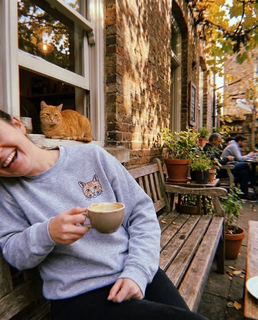 Person wearing a custom cat portrait sweatshirt with their cat nearby