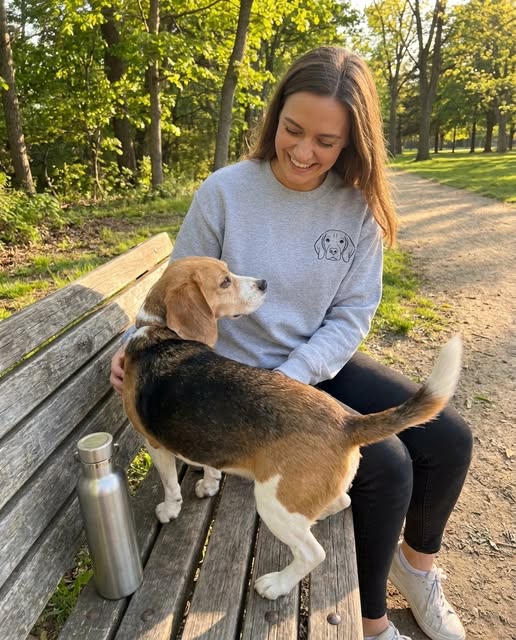 Person wearing a grey custom dog portrait sweatshirt with their dog at a park